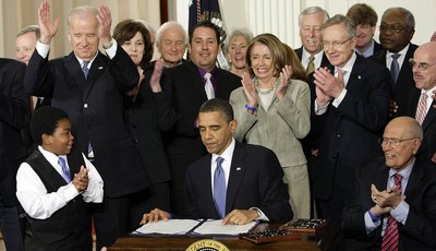 
              FILE - In this March 23, 2010, file photo, participants applaud in the East Room of the White House in Washington, Tuesday, March 23, 2010, as President Barack Obama, flanked by Macelas